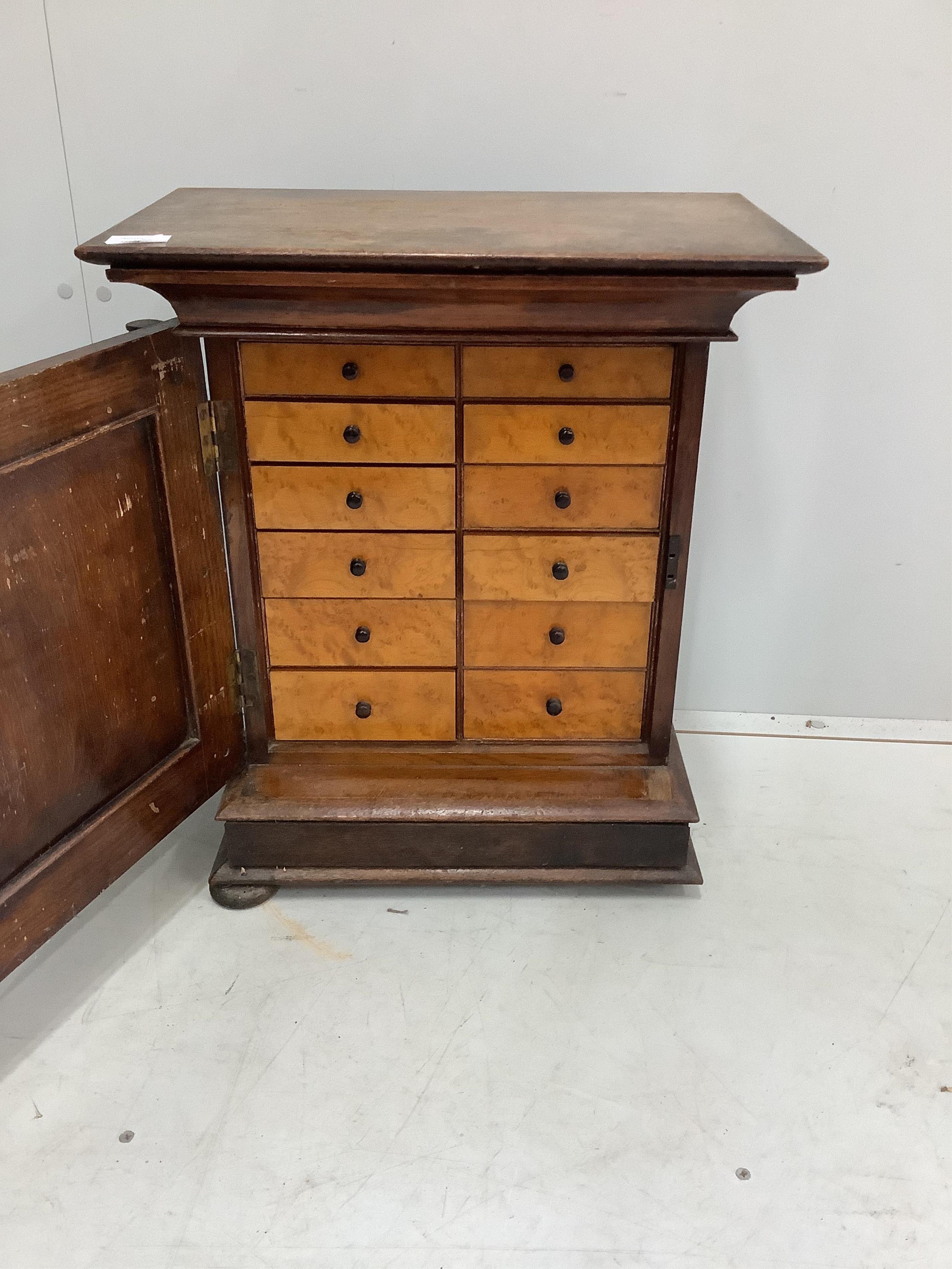 A small Italian carved oak and walnut collector's chest, fitted ten bird's eye maple faced drawers, width 49cm, depth 29cm, height 58cm. Condition - fair